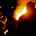 Out of the blackness emerge a dozen men, eight who are brandishing a heavy raft piled high with cuts of timber. Another three carry ten-foot flagpoles; a torch is borne by the final man, flames leaping.